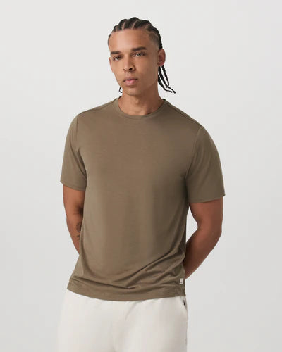 Man wearing a Vuori - Current Tech Tee in Peppercorn against a white background