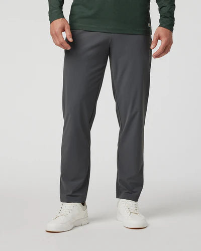 Person wearing dark gray Vuori - Fleet Chino Pant Athletic Slim 30" pants on a plain background