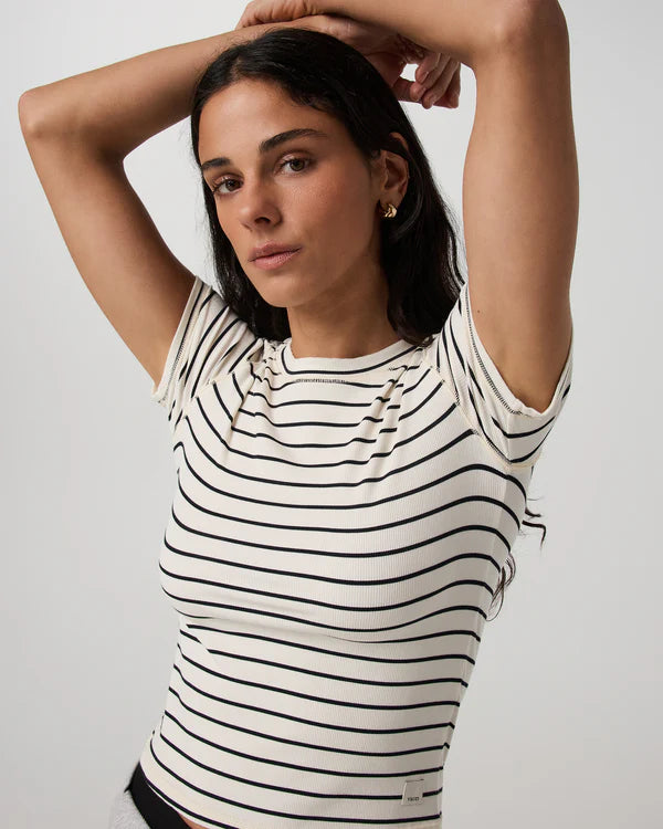 Woman wearing a Vuori - Pose Fitted Tee Ink Stripe shirt against a plain background
