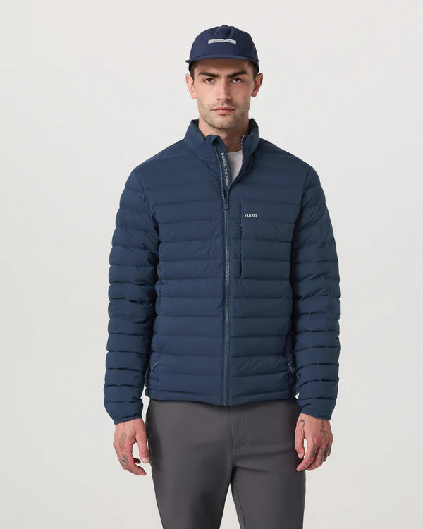 Man wearing a Vuori - Steadfast Insulated Full Zip Jacket and cap on a light gray background