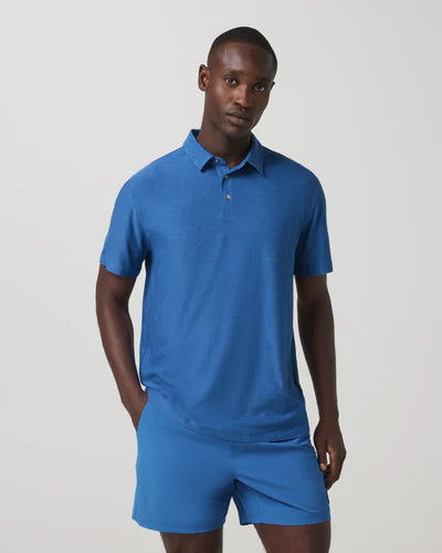 Man wearing a Vuori - Strato Tech Polo and shorts on a light gray background
