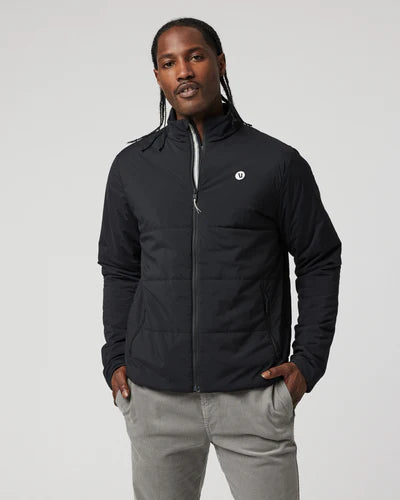 Man wearing a black Vuori Echo Insulated Jacket 2.0 with a logo on a gray background